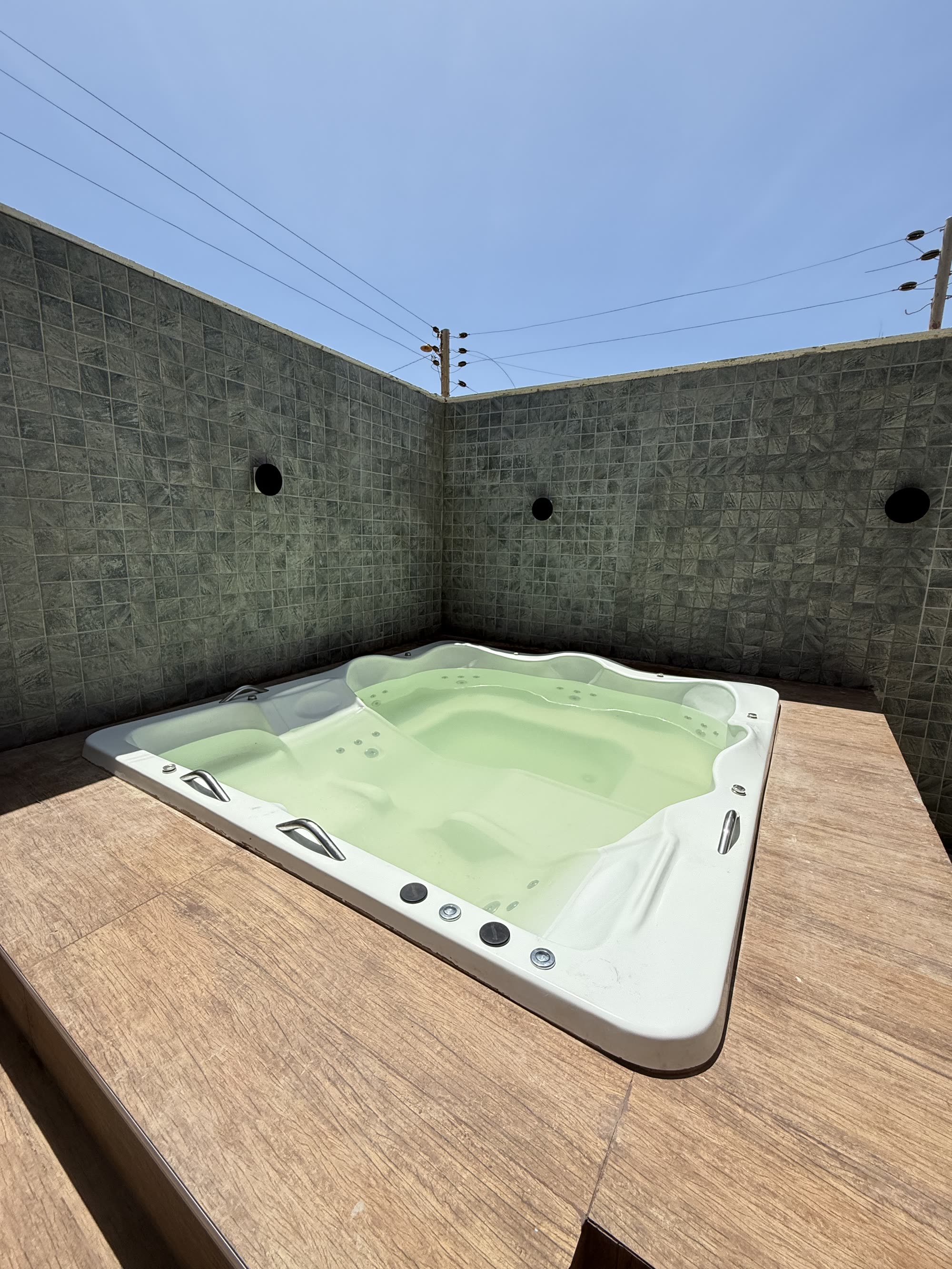 Jacuzzi em deck de madeira na área privativa