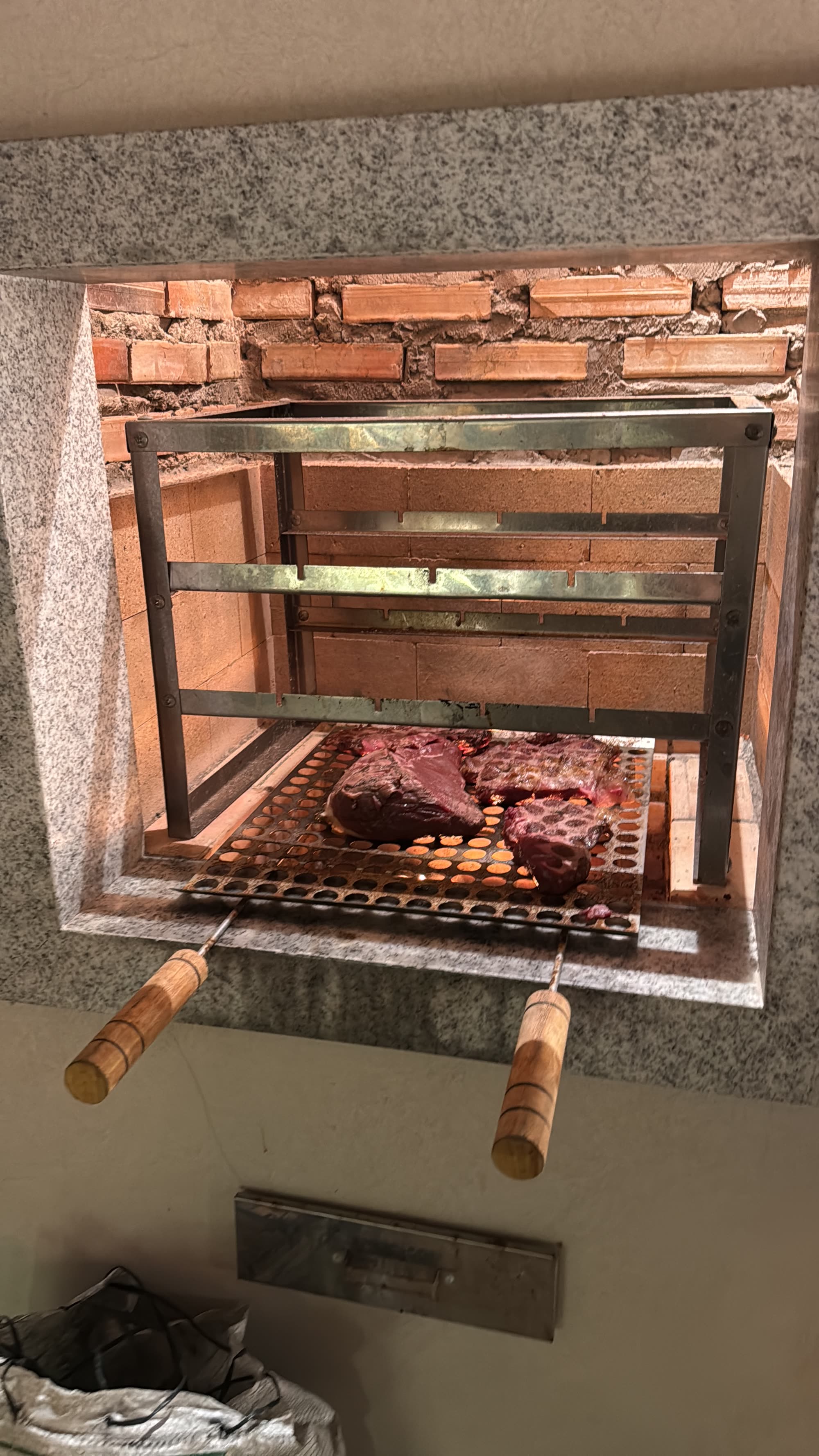 Churrasqueira acesa com carne na grelha